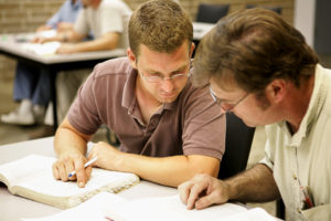 Dois alunos de educação para adultos estudando juntos em classe.