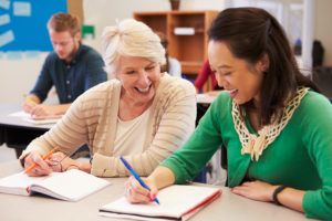 Teacher and student sit together at an adult education class