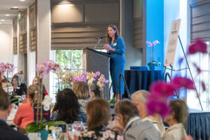 Speaker presenting at podium with event signage visible during the Literacy Matters Luncheon.