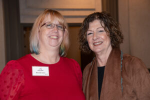 Two attendees smiling and posing together at the Literacy Matters Luncheon.