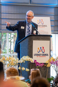 Master of Ceremonies Jeffery Kin speaking on stage during the Literacy Matters event program.