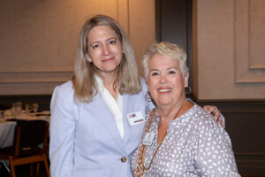 Two attendees smiling and posing together at the Literacy Matters Luncheon.
