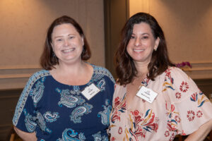 Two attendees smiling and posing together at the Literacy Matters Luncheon.