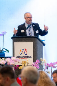Master of Ceremonies Jeffery Kin speaking on stage during the Literacy Matters event program.