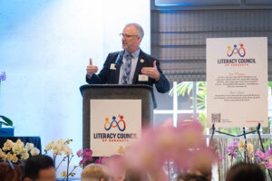 Master of Ceremonies Jeffery Kin speaking on stage during the Literacy Matters event program.