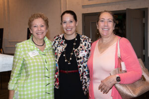 three attendees smiling and posing together at the Literacy Matters Luncheon.