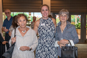 Three attendees smiling and posing together at the Literacy Matters Luncheon.