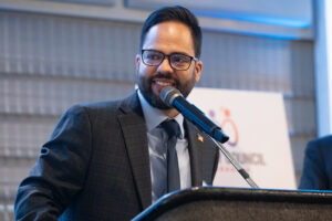 Speaker presenting at podium with event signage visible during the Literacy Matters Luncheon.