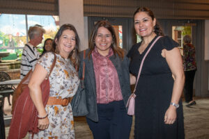 Three attendees smiling and posing together at the Literacy Matters Luncheon.