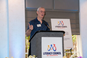Volunteer of the Year recipient smiling on stage after receiving award at the Literacy Matters Luncheon.