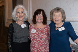 Three attendees smiling and posing together at the Literacy Matters Luncheon.