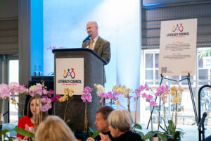 Presenter delivering remarks during the Literacy Matters Luncheon while audience listens attentively.