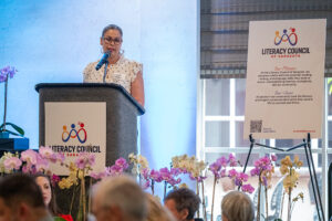 Presenter delivering remarks during the Literacy Matters Luncheon while audience listens attentively.