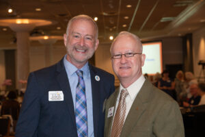 Two attendees smiling and posing together at the Literacy Matters Luncheon.