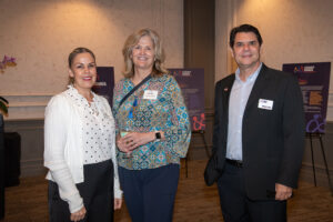 Three attendees smiling and posing together at the Literacy Matters Luncheon.