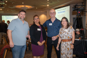 Four attendees smiling and posing together at the Literacy Matters Luncheon.