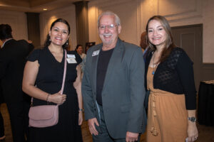 Three attendees smiling and posing together at the Literacy Matters Luncheon.