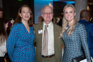 Three attendees smiling and posing together at the Literacy Matters Luncheon.