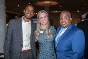 Three attendees smiling and posing together at the Literacy Matters Luncheon.