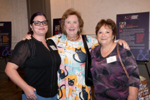 Three attendees smiling and posing together at the Literacy Matters Luncheon.