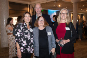Four attendees smiling and posing together at the Literacy Matters Luncheon.