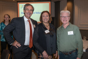 Three attendees smiling and posing together at the Literacy Matters Luncheon.