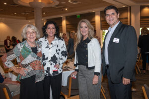 Four attendees smiling and posing together at the Literacy Matters Luncheon.