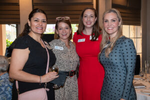 Four attendees smiling and posing together at the Literacy Matters Luncheon.