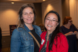 Two attendees smiling and posing together at the Literacy Matters Luncheon.