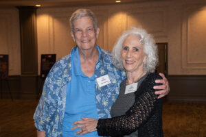 Two attendees smiling and posing together at the Literacy Matters Luncheon.
